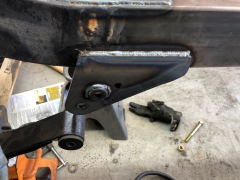 1992 Jeep Wrangler - Welding and suspension work on a vehicle frame is shown, with tools and jack stands in the background.