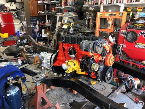 1992 Jeep Wrangler - Engine assembly undergoing work in a workshop environment with tools and parts visible.