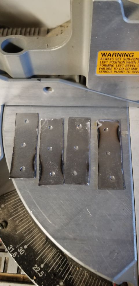 1996 Ford Bronco - Four metal plates with screw holes are positioned on the base of a miter saw.