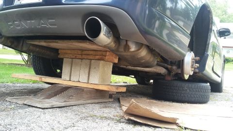 2000 Pontiac Grand Prix rear axle with wheel removed, supported by wood and bricks