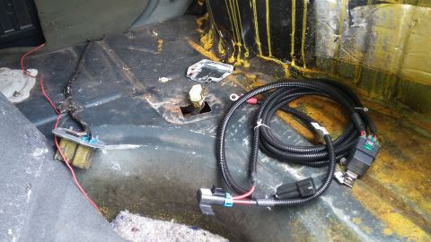 Car interior with a wiring harness and red wires on the floor