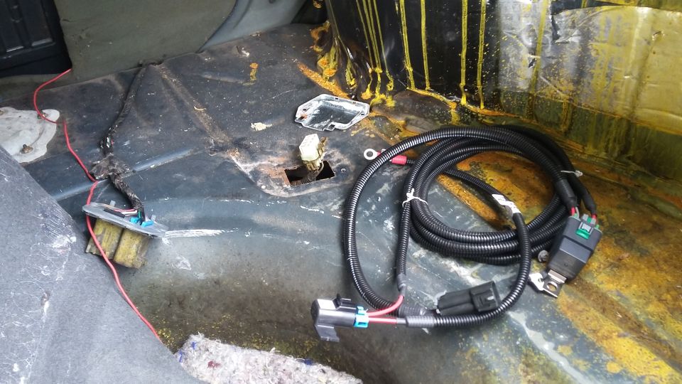 Car interior with a wiring harness and red wires on the floor