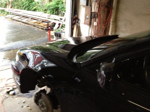 Black 2000 Pontiac Grand Prix with hood open and front wheel removed