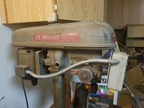 1978 Ford Bronco - A drill press sits in a cluttered workshop area, with cabinets above and boxes in the background.