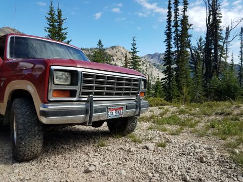 1985 Ford Bronco - This 1985 Ford Bronco is seen parked on a gravel road with a mountainous backdrop.