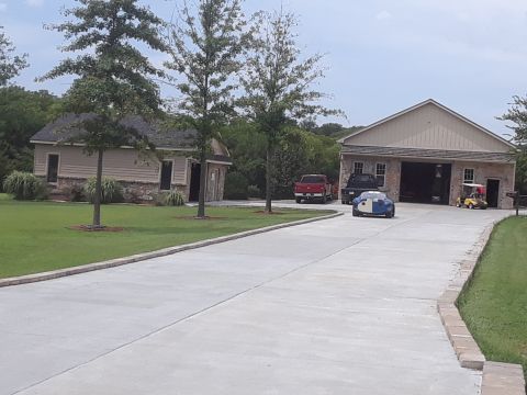 1994 Ford Bronco - A two-tone sports car is seen on a driveway with two trucks and a golf cart near a large garage.