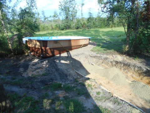 1992 Ford Bronco - An above-ground pool is positioned on a dirt and gravel base near a hole dug for its installation.