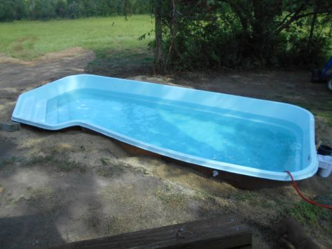 1992 Ford Bronco - An above-ground swimming pool is partially installed in a yard, with water filling its basin.