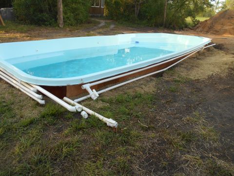 1992 Ford Bronco - An above-ground swimming pool is partially installed with PVC pipes connected to its filtration system.