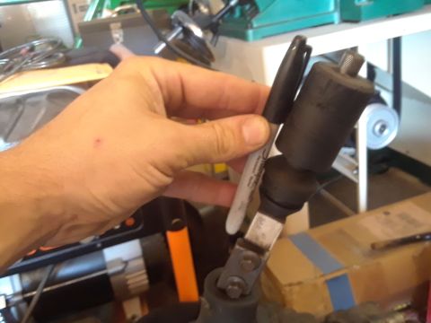 1996 Ford F-350 - A hand holds a marker near a vehicle's shift lever assembly, possibly for marking a measurement.
