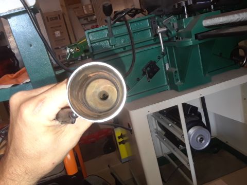 1996 Ford F-350 - A metal pipe is held up to the camera, obscuring a green industrial machine and a motor.