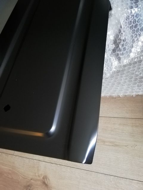 1996 Ford Bronco - Unidentified black metal panel, possibly a car part, shown in close-up.