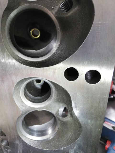 1996 Ford Bronco - Close-up of an engine cylinder head showing machined ports and bolt holes.