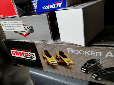 1996 Ford Bronco - Several boxes of automotive parts, including COMP Cams rocker arms, are stacked together.