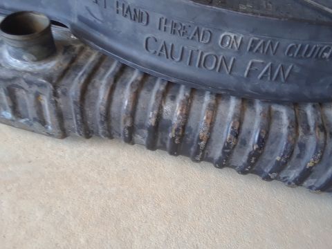 1994 Ford Bronco - Close-up of a radiator and fan clutch, showing text that reads "HAND THREAD ON FAN CLUTCH CAUTION FAN".