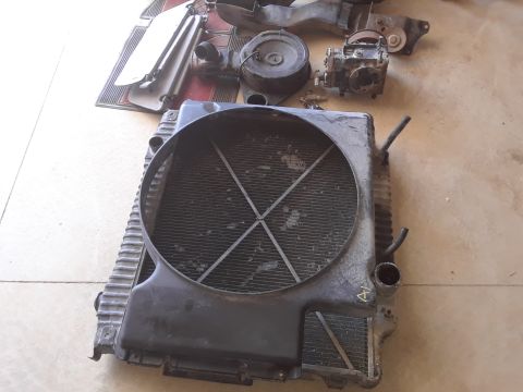 1994 Ford Bronco - Collection of vehicle parts including a radiator, air cleaner, and carburetor.