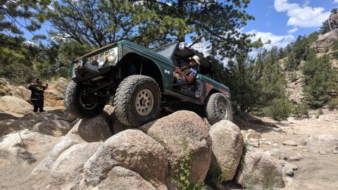 1995 Ford Bronco - Modified Ford Bronco tackling a challenging off-road course with large boulders.