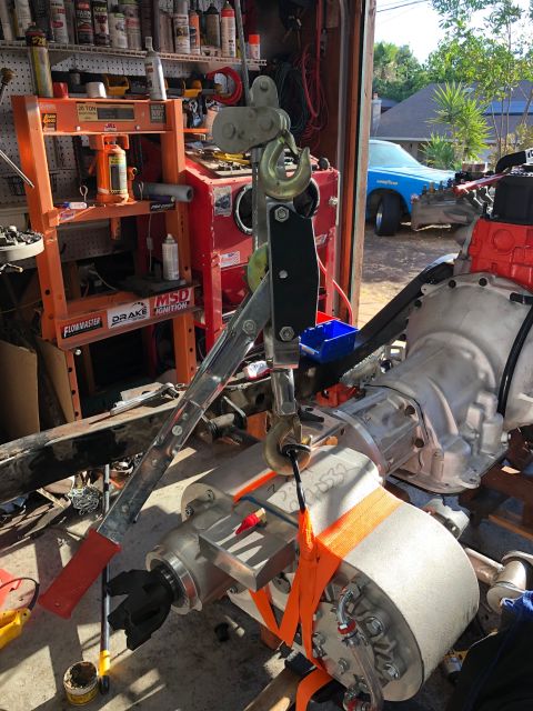 1992 Jeep Wrangler - Engine and transmission assembly being worked on in a garage, with a blue car in the background.