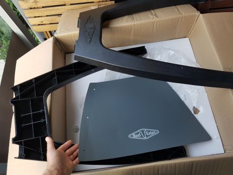 1978 Ford Bronco - Unboxed parts, including a gray panel with a "Reef Eater" logo and black plastic components, are shown inside a cardboard box.