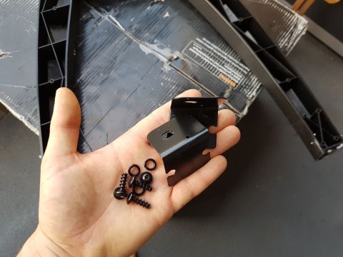 1978 Ford Bronco - Metal brackets and fasteners are held in a hand, with packaging in the background.