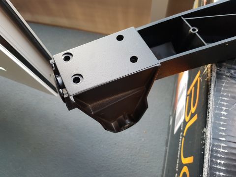 1978 Ford Bronco - Close-up view of a black metal bracket attached to a section of a vehicle frame.