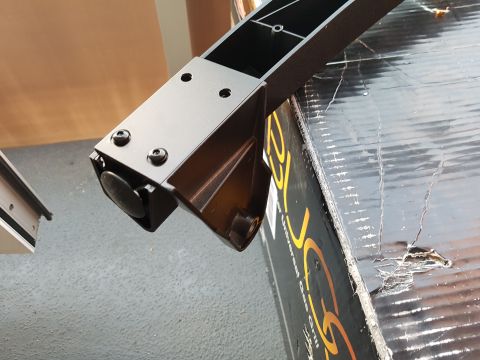 1978 Ford Bronco - A close-up view of a black metal frame component, possibly for a grill, resting on a damaged cardboard box.