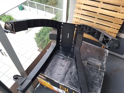 1978 Ford Bronco - A black plastic car part is shown resting on a damaged box, with the Supermotors logo visible in the lower right corner.