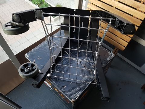 1978 Ford Bronco - The frame of a shopping cart, including its wheels and wire basket, is shown from an elevated angle.