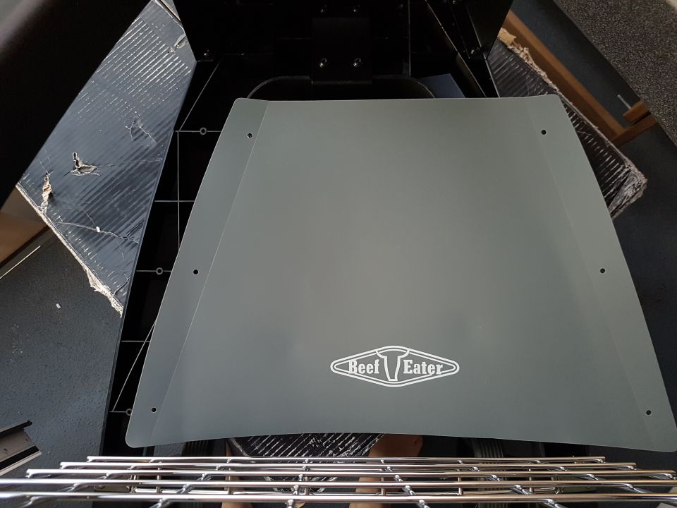 Gray grill lid with 'BeefEater' logo, showing metal grates below