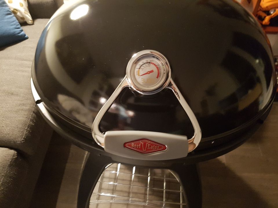 Black barbecue grill with thermometer and 'BeefEater' logo on handle