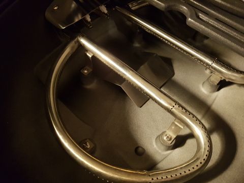 1978 Ford Bronco - This image shows the internal components of a gas grill, specifically the burner assembly and igniter.