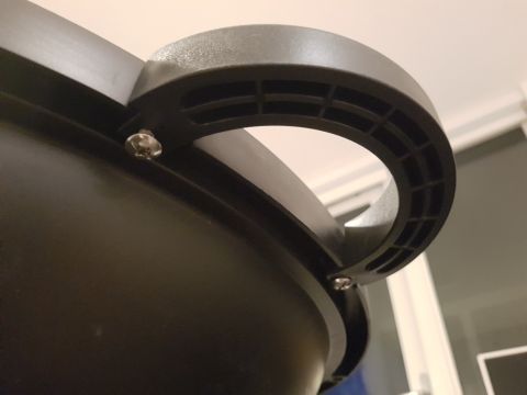 1978 Ford Bronco - A close-up view of a black plastic handle secured by screws to a curved surface.