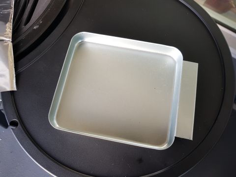 1978 Ford Bronco - A metal tray sits on a black surface, with a piece of foil to its left.
