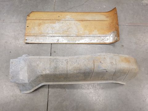 1978 Ford Bronco - Two weathered automotive parts, likely from an older vehicle, are displayed on a concrete surface.