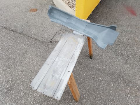 1978 Ford Bronco - Two automotive body panels are prepped for painting on sawhorses outside.