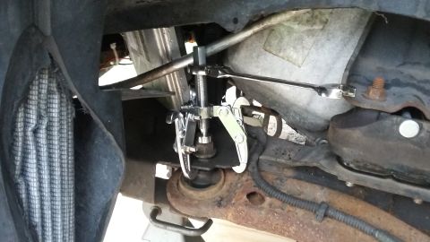 Gear puller tool attached to a vehicle's suspension component