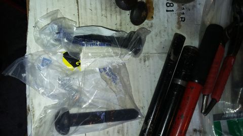 Several new automotive parts in plastic packaging next to various tools on a workbench