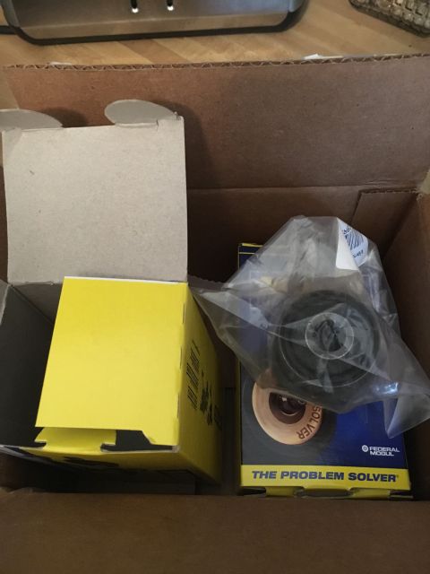 1996 Ford Bronco - Auto parts are packaged in a cardboard box, with visible branding and a component wrapped in plastic.