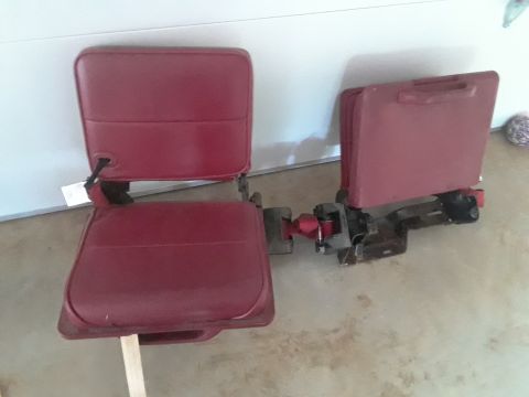 1994 Ford Bronco - Two red car seats are shown, detached from a vehicle and resting on a concrete floor.