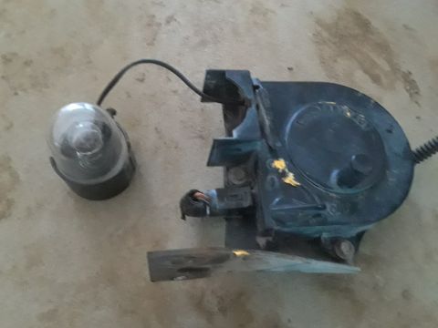 1994 Ford Bronco - This is a fog light assembly, likely for a vehicle, with a clear lens and black housing.