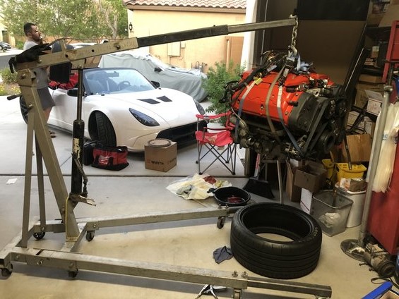 2000 Lotus Esprit engine being lifted out by an engine hoist in a garage