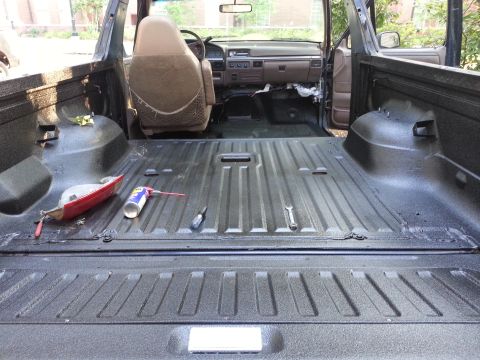1995 Ford Bronco - The interior of a 1995 Ford Bronco shows a freshly sprayed truck bed and the exposed cabin area.