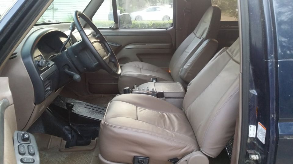 Interior of a truck with tan leather seats, steering wheel, and dashboard. A Supermotors logo is in the lower right corner