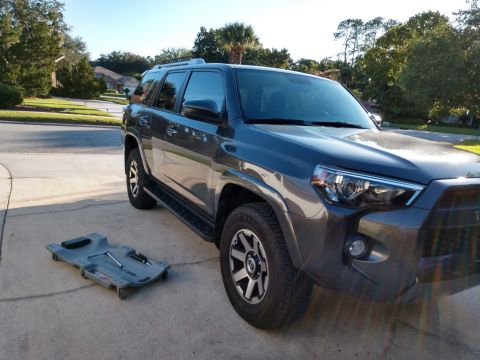 2018 Toyota 4Runner - A dark gray 2018 Toyota 4Runner is parked on a driveway next to a creeper with tools.