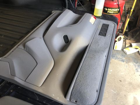 1995 Ford Bronco - Car door panel removed from vehicle, showing interior trim and fabric details.