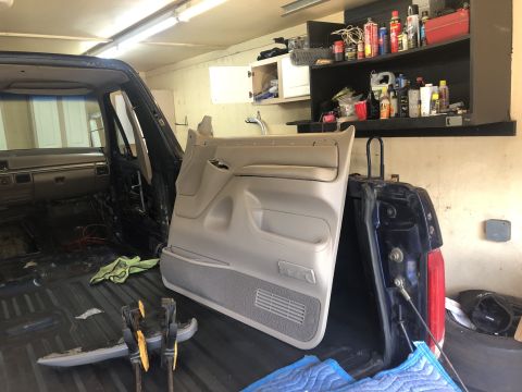 1995 Ford Bronco - Vehicle interior is partially disassembled, showing removed door panel and exposed dashboard components.