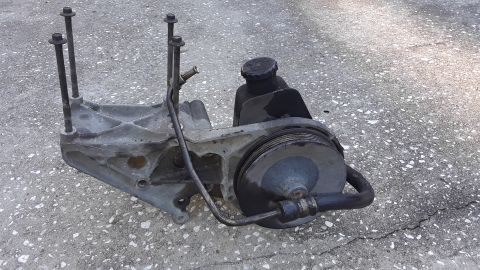 1994 Ford Bronco - This power steering pump assembly is shown on a concrete surface.