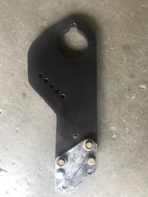 2000 Ford Explorer - A black metal bracket with a large circular opening and multiple bolt holes is shown against a concrete surface.