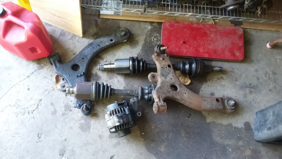 Automotive parts: control arms, CV axles, alternator, and red gas can