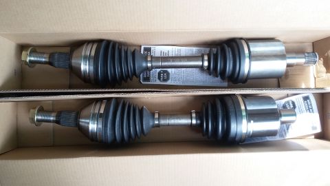 Two new CV axles in a cardboard box, with instructions